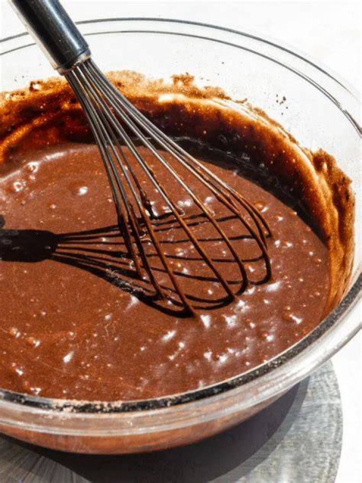 Chocolate cake batter in a glass bowl.