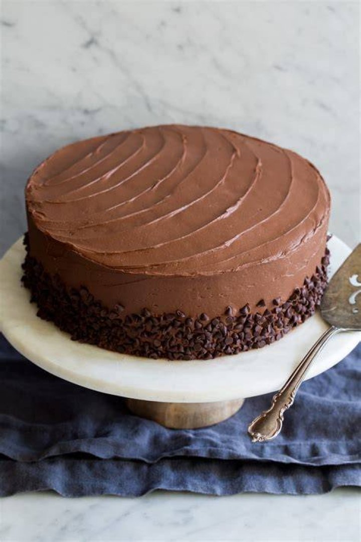 Chocolate cake with chocolate icing in a white baking dish.