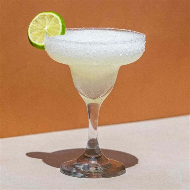 Frozen margarita in a glass on a silver platter.