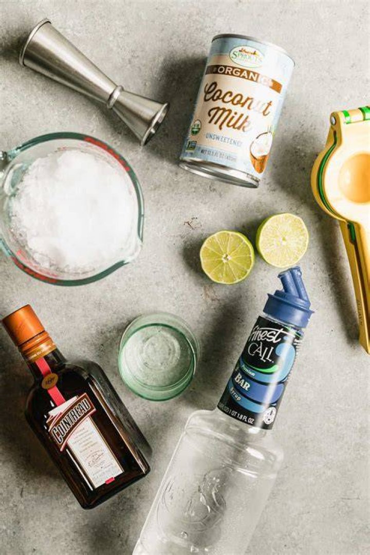 Ingredients for making coconut margaritas (tequila, triple sec, limes, coconut milk)