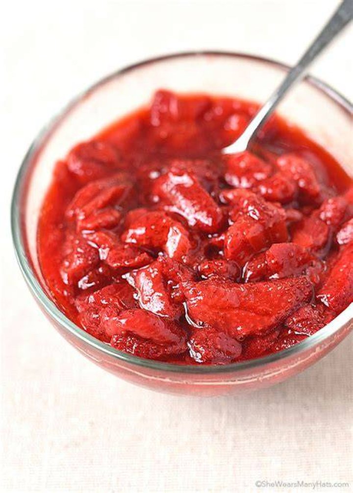Roasted strawberries and strawberry sauce in a glass jar.
